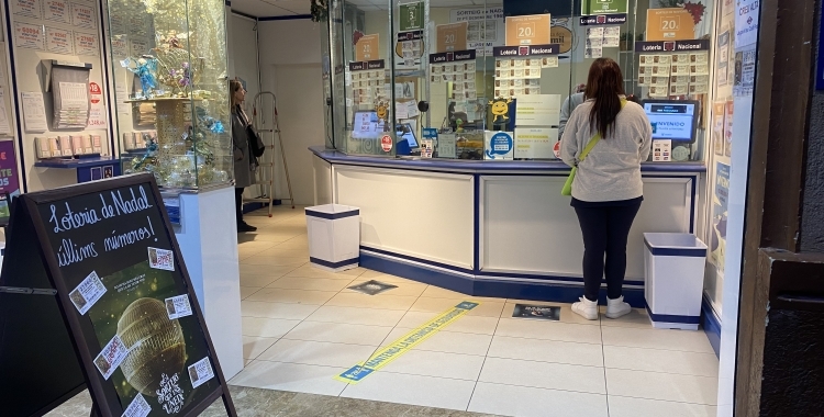 Una clienta comprant loteria en una administració | Arxiu