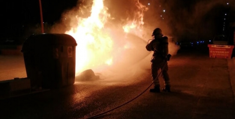 Un bomber treballant en l'extinció d'un incendi en un contenidor | Roger Benet