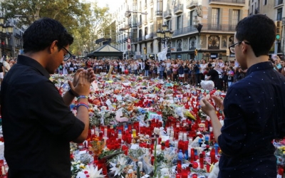 Dos joves aplaudeixen després d'haver fet l'ofrena a les víctimes dels atemptats de Barcelona i Cambrils | ACN