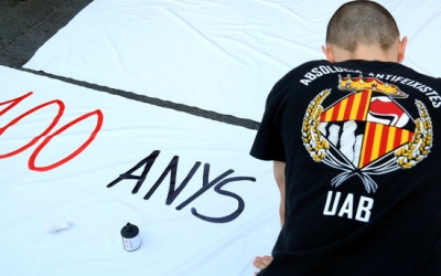 Estudiant escrivint cartell a l'acampada indefinida a la plaça Universitat | ACN