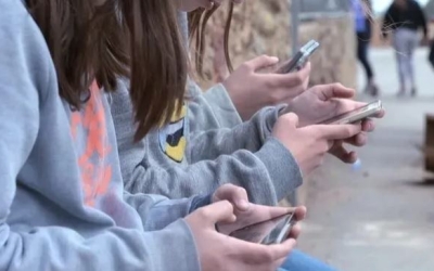 Adolescents utilitzant el mòbil en un centre escolar | cedida