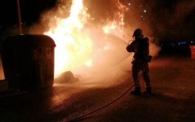 Un bomber treballant en l'extinció d'un incendi en un contenidor | Roger Benet